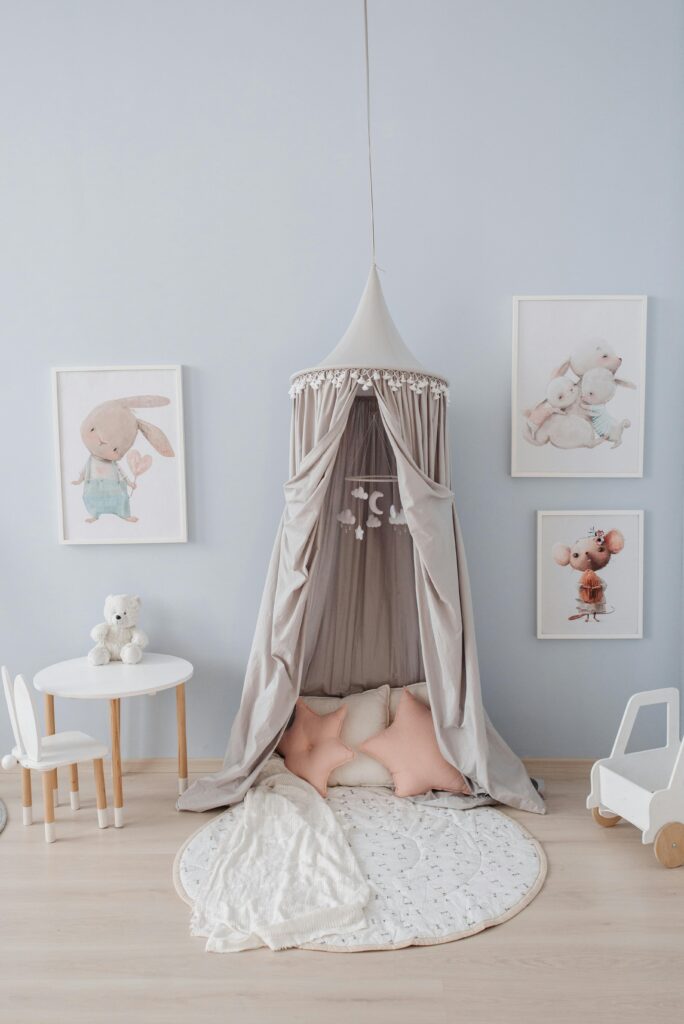 白いクマのぬいぐるみや白い机、ピンクの星型クッションなどが置いてある子ども部屋