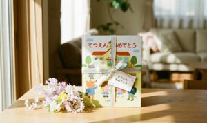 日差しの入るリビングの木のテーブルに、リボンでラッピングされた卒園祝いの絵本と小さな花束が置かれている